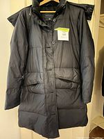 Full view of black quilted puffer coat hanging