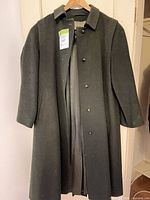Full front view of overcoat hanging, showing color, length, button front, pockets