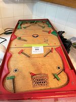 Top view of Burlington wood bagatelle showing paddles, pins, basket and overall wear