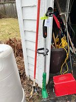 Full view of string trimmer, pole tool, toolbox