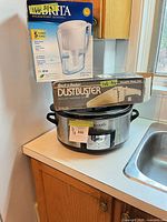 All three items grouped: Crock-Pot slow cooker, Brita pitcher box, Black & Decker DustBuster box