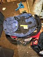 Blue MEC backpack atop black and blue duffel