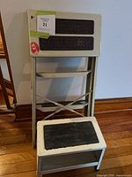 Both ladder and rolling stool stacked for scale