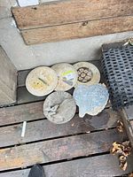 Five garden decor pieces; four stepping stones with mosaic designs and one concrete sundial