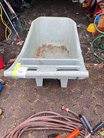 Top angled view of entire plastic garden cart showing handles, tub interior and condition