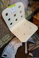 Front view of white IKEA chair showing seat/back holes and overall design