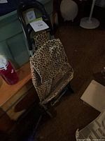 Full view of leopard print rolling cart showing bag pattern, handle and wheels