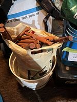 Bag filled with brown wooden Lincoln Logs dowels