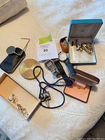 Group view of watches, cufflinks, tie clips, loupe, boxes