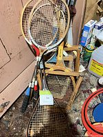Group of racquets and presses leaning against wall