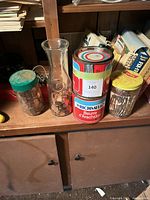 All four coin-filled containers on shelf
