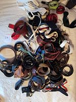 Pile of assorted belts showing quantity and variety