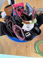 Top view of blue bowl holding assorted sunglasses, cases, straps and cloth