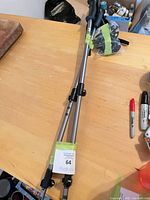 pair of telescoping poles collapsed with lot tag visible