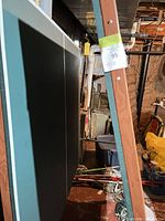 Side view of folded green table tennis panels with wood trim