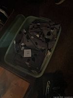 Green Rubbermaid bin filled with patterned upholstery fabric remnants