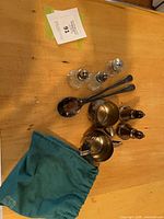Full lot top view: creamer, sugar, two tall shakers, two glass shakers, two serving spoons, condiment jar, teal pouch