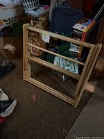 Rack folded flat showing natural wood frame and horizontal rods