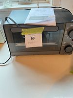 Front view Sunbeam toaster oven with manual on top