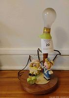Full view of lamp with bulb and attached figurines
