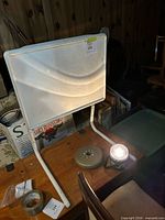 Front view of folding TV tray with weight and light source