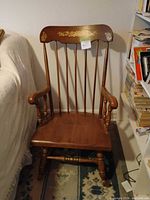 Front view of Windsor-style armchair showing spindle back, arms, turned legs