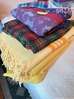 Stack of four blankets on bed