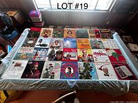 Overhead view of 30 assorted Christmas vinyl records laid out with sleeves visible