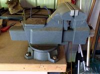 Side view of Craftsman vise on bench, showing swivel base and anvil pad