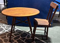 Child's round wooden table and chair side by side