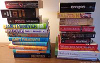 Two stacks of assorted books showing titles and authors