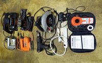 All tools laid out: two belt sanders, two jigsaws, drill, circular saw, Bullseye kit, soldering iron, power bar, sanding media