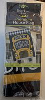 Front of sealed Briarwood Lane house flag package showing bus design and product details