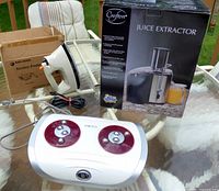 Lot overview showing Crofton juice extractor box, steam iron, HoMedics foot massager