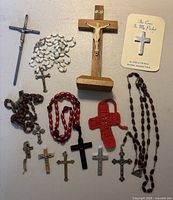 assortment of crucifixes, rosaries, pendants, crochet cross and pocket card