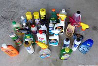 Full group of roughly 24 assorted cleaning and maintenance products on concrete floor