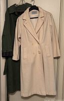 Both coats hanging side by side on hangers