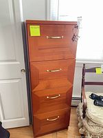Full view of 4-drawer cherry veneer file cabinet with brass pulls
