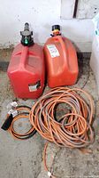 Two gas cans, coiled extension cord, splitter visible