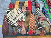 Overview of assorted neckties laid out with two white multi-tie hangers visible