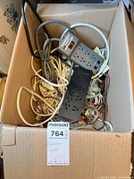 Box containing assorted power strips and extension cords