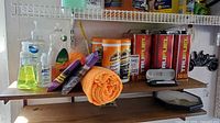 Shelf with TruFuel cans, Armor All wipe canisters, towels and grey tool case