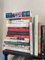 Stack of assorted hardcover and paperback books showing health, politics and management titles