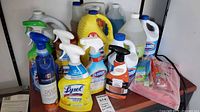 Full lot of assorted cleaning bottles, jugs, sprays, sponges, fire blanket on shelf