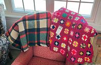 Plaid wool blanket and crocheted afghan draped over chair