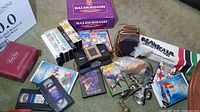 Mixed lot showing board games, VHS tapes, DVDs, metal grinder & cookie press parts, speaker wire