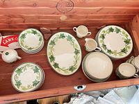 All pieces inside chest showing platter, plate stacks, cups, creamer, sugar bowl