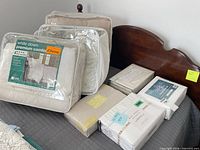 Overall lot showing two comforters and stacked sheet sets