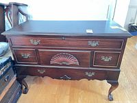 Front view of Lane cedar chest showing carved shell motif, drawers, brass pulls, cabriole legs