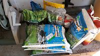 Group of assorted fertilizer bags on garage floor